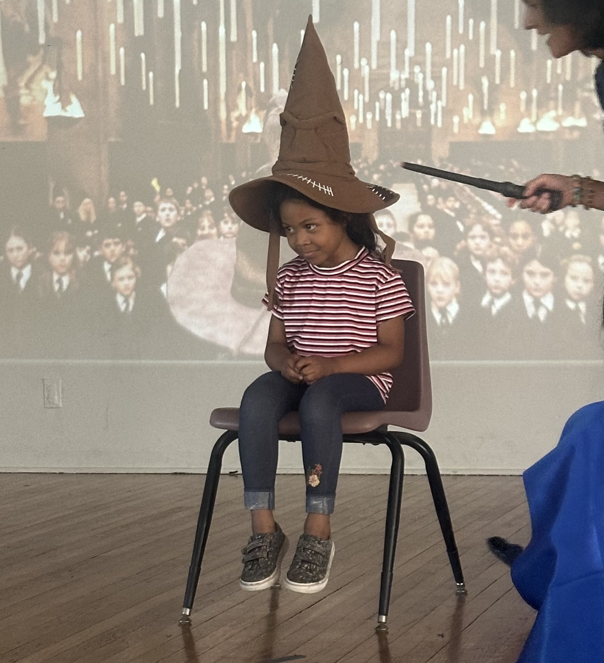 A little girl waits in the sorting hat chair