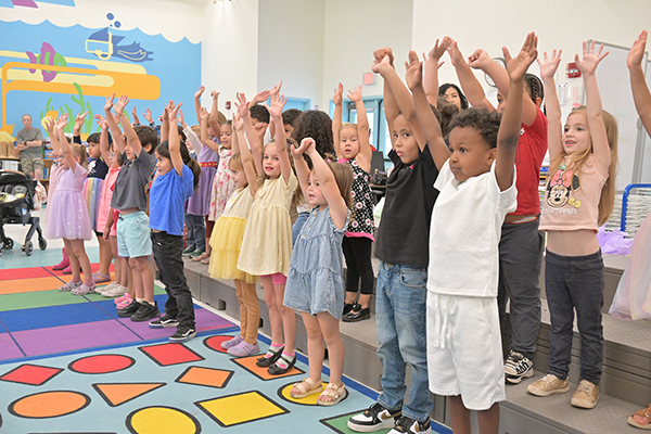 Students wave their hands in the air during a performance