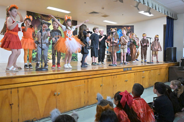 Children perform while their peers watch.