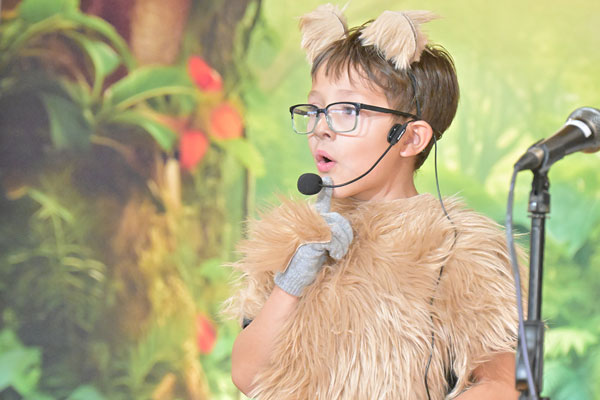 Child costumed as an animal performs.