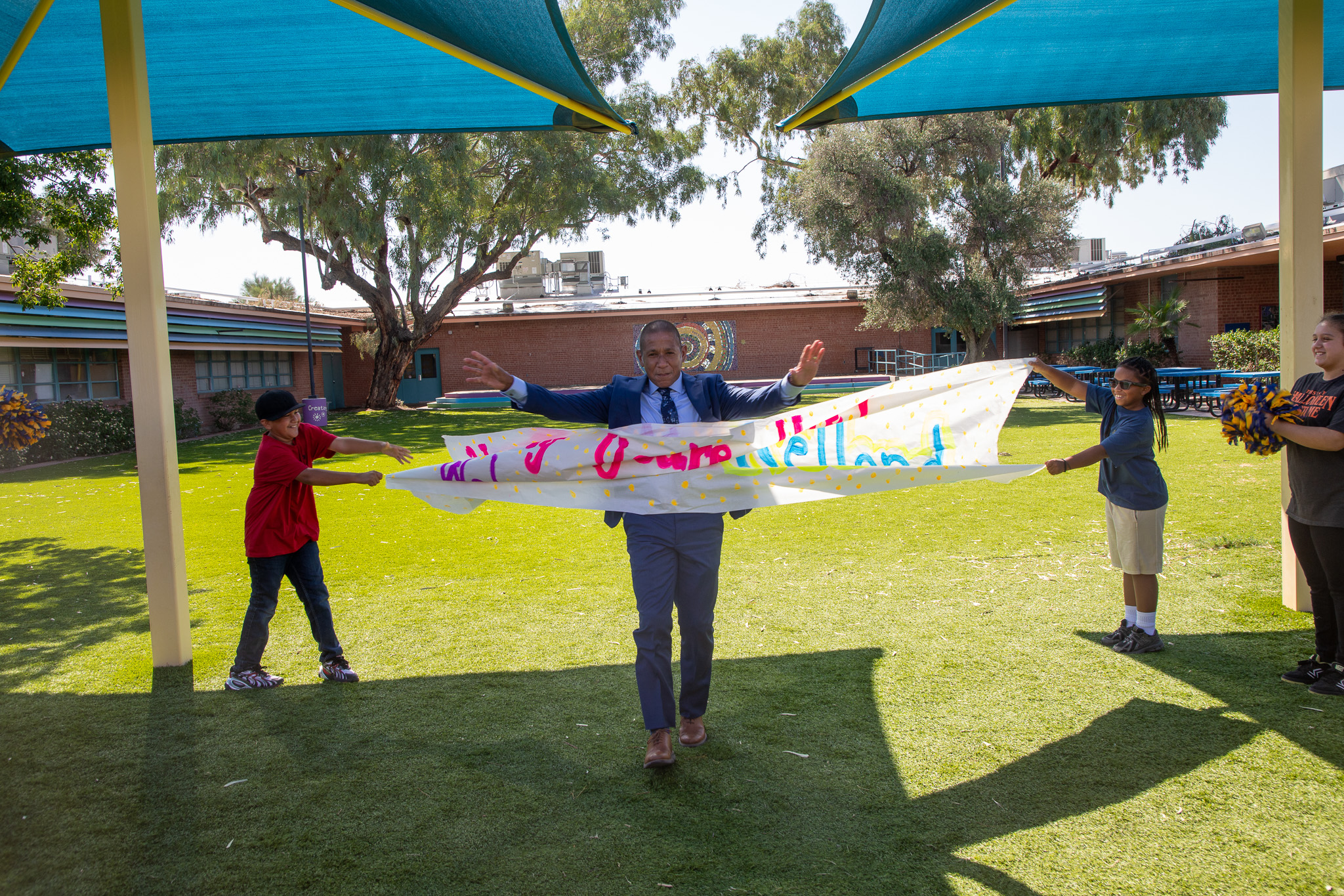 Dr.Trujillo bursts through a paper welcome banner outside